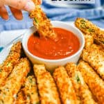 A hand dipping a crispy Air Fryer zucchini stick into a small bowl of marinara with a text overlay on the photo