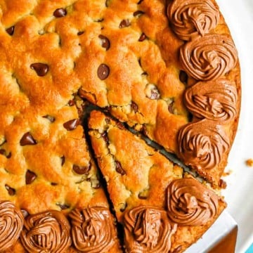 A slice being taken out of a chocolate chip cookie cake