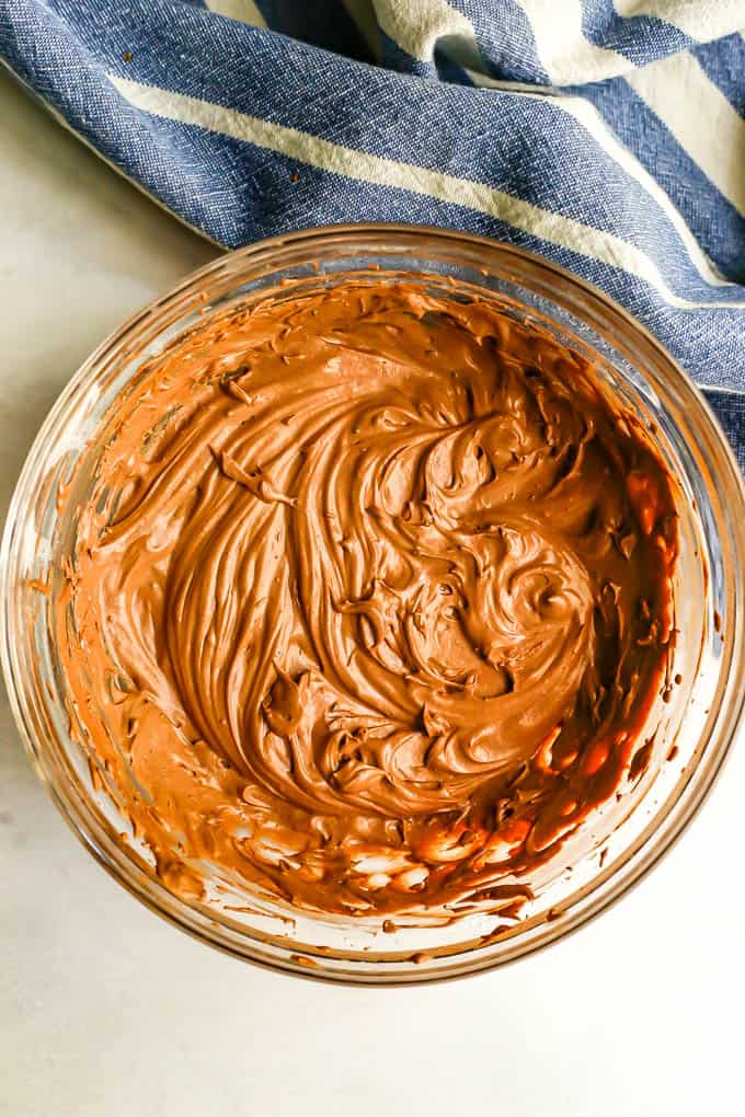 A clear glass bowl with homemade chocolate frosting