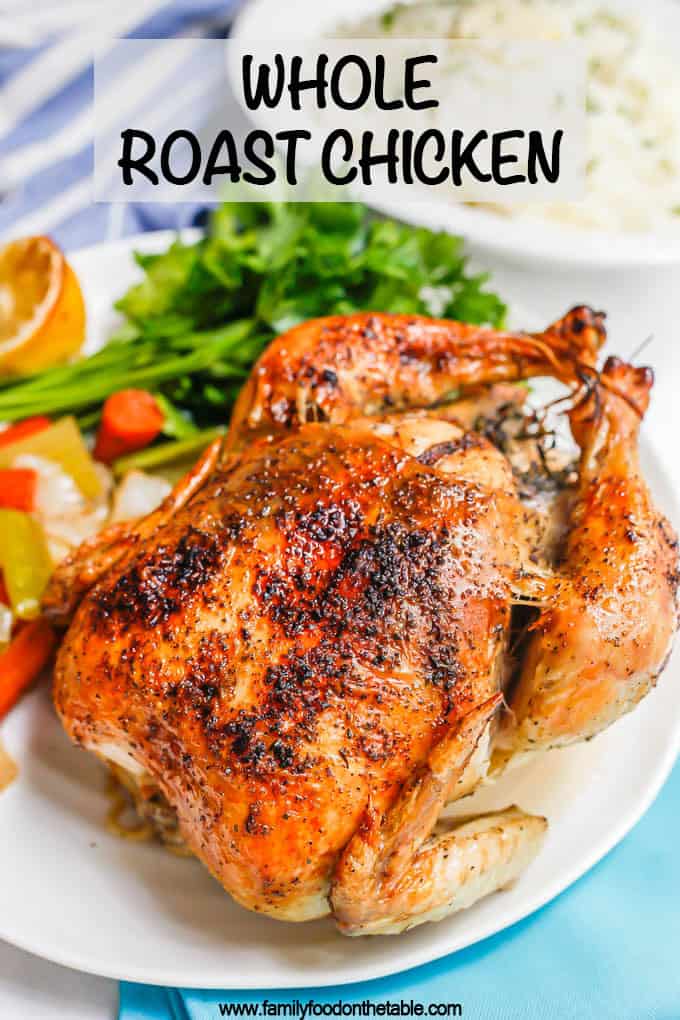 A browned and crispy whole roasted chicken on a platter with roasted veggies and fresh parsley with a text overlay on the photo