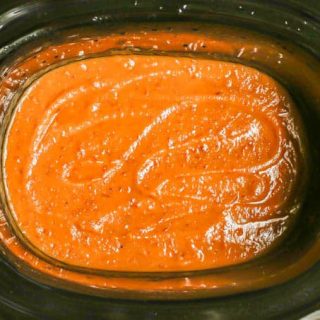 Pureed, smooth applesauce in a black slow cooker insert after cooking