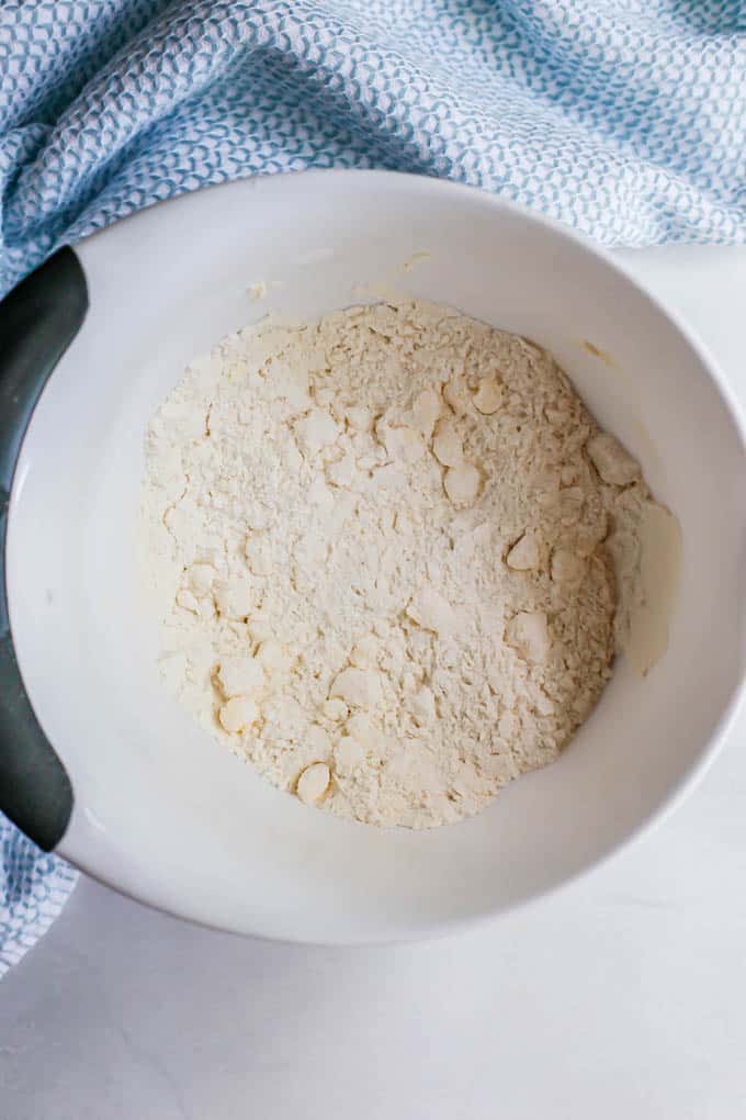 A small white bowl with a flour and butter mixture cut together