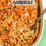 Green bean casserole with French fried onions on top in a white oval baking dish after cooking and a text overlay on the photo