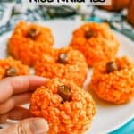 A hand picking up a pumpkin Rice Krispie treat from a plate with a text overlay on the photo