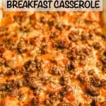 A cheesy sausage and egg breakfast casserole in a white baking dish with a text overlay on the photo