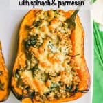 Half of a butternut squash stuffed with turkey sausage and spinach and topped with browned Parmesan cheese with a fork stuck in it and a text overlay on the photo