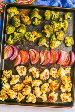Roasted broccoli, cauliflower and red onion on a sheet pan