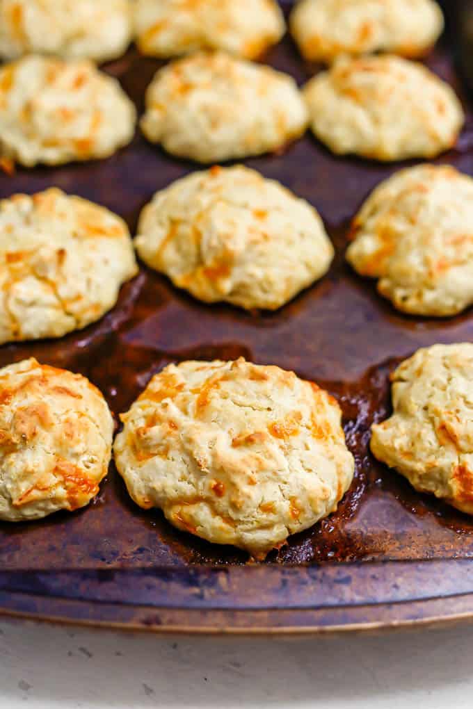 Baked cheddar garlic drop biscuits on a baking sheet