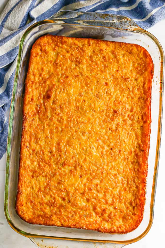 Golden brown corn pudding in a glass casserole dish after being baked in the oven