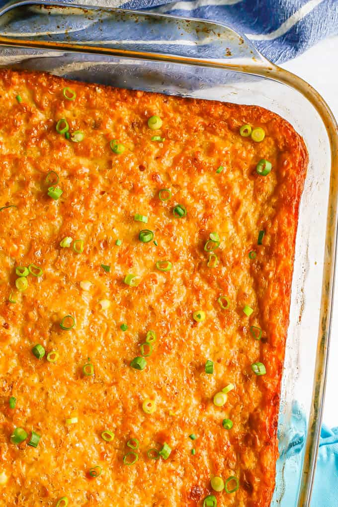 Close up of corn pudding casserole after being baked with sliced green onions sprinkled on top