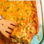 A square piece of corn pudding lifted up on a wooden spatula from the casserole dish with a text overlay on the photo