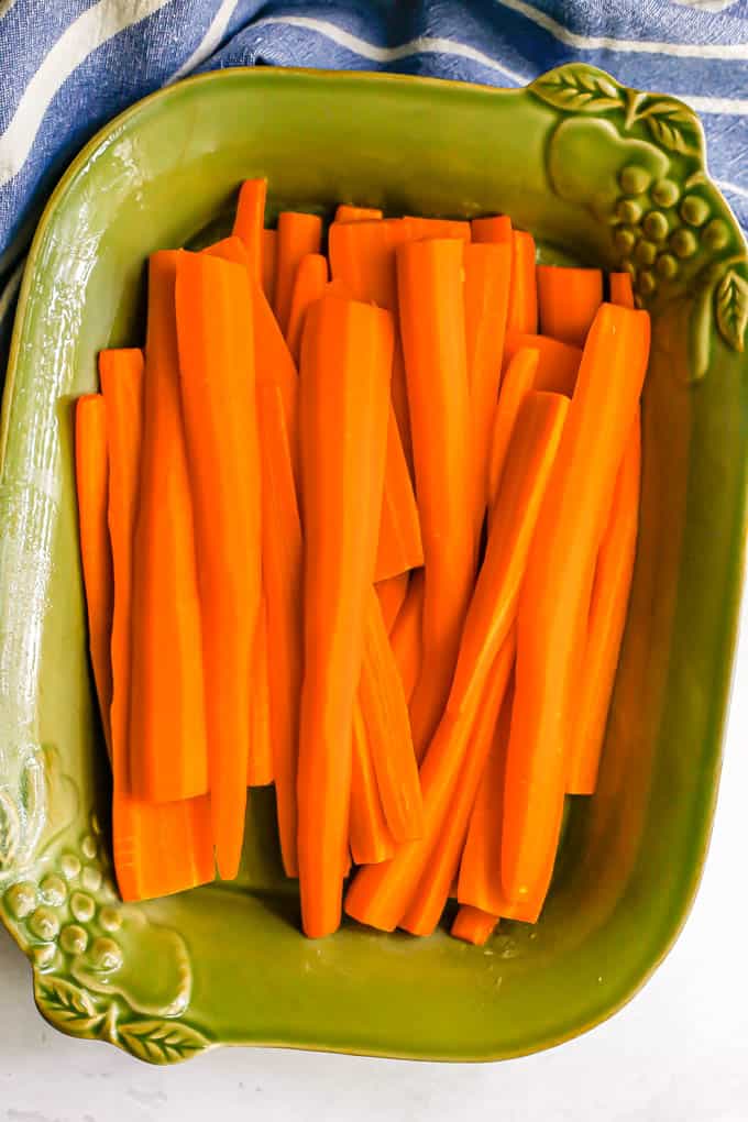 Boiled cut carrots in a green baking dish