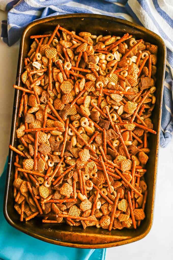 A baking pan full of homemade Chex mix with cereals, pretzels and peanuts after being baked in the oven