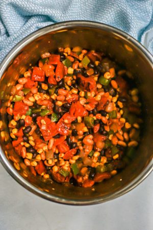 A mixture of beans, corn and tomatoes in an Instant Pot before being cooked