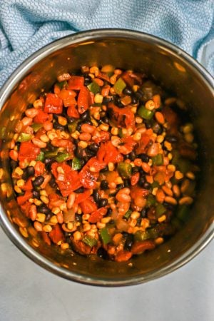 A mixture of beans, corn and tomatoes in an Instant Pot before being cooked