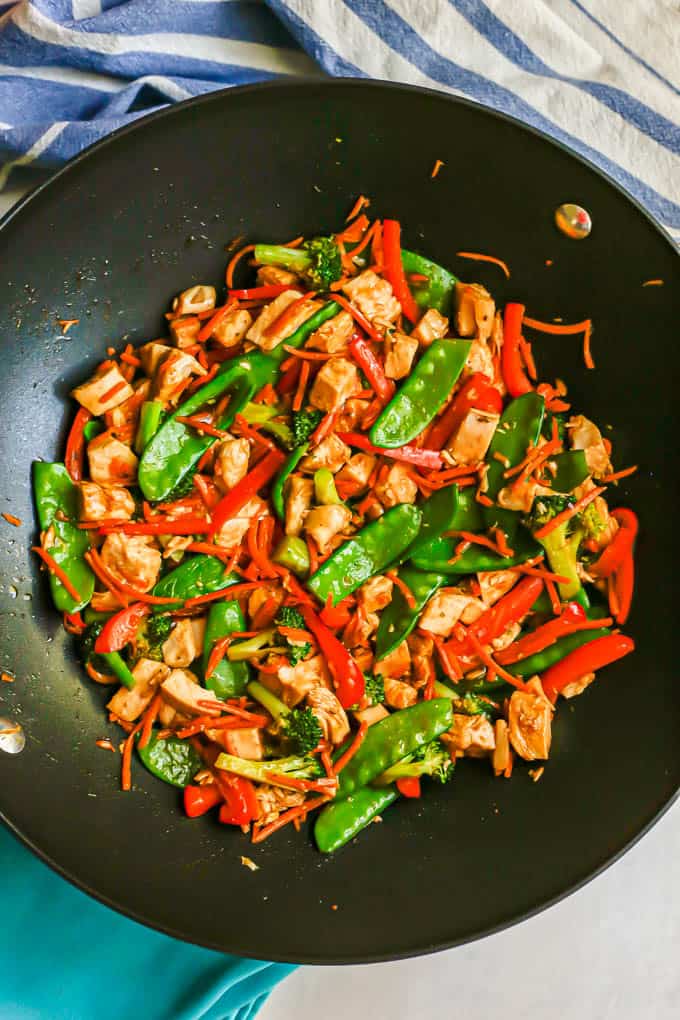 Diced turkey and colorful vegetables in a stir fry sauce in a large wok
