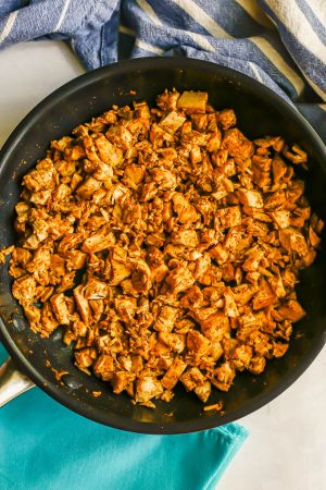 A skillet with diced leftover Thanksgiving turkey seasoned with taco seasoning and warmed through