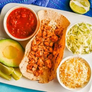 Overhead shot of a diced turkey taco with rice and bowls of toppings to the side