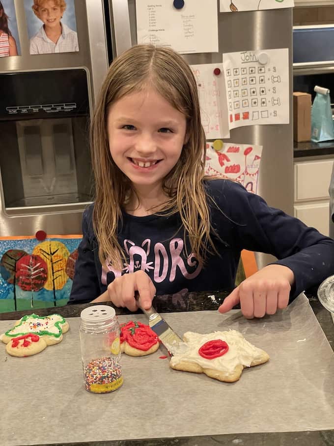 A little girl decorating a sugar cookie