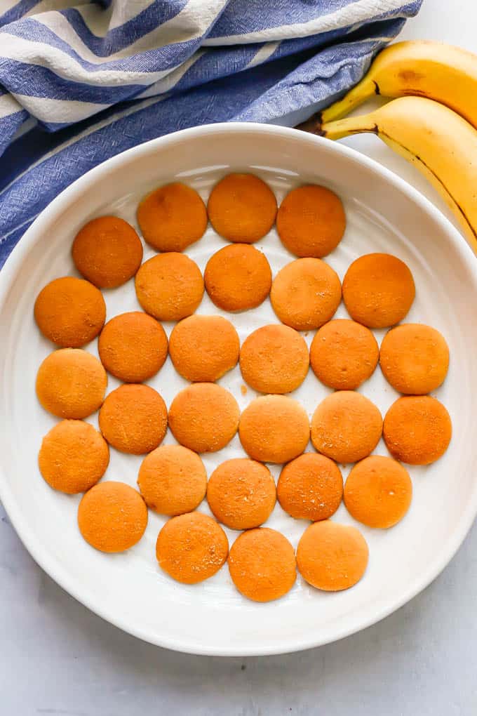 A layer of Nilla wafers in a large white casserole dish