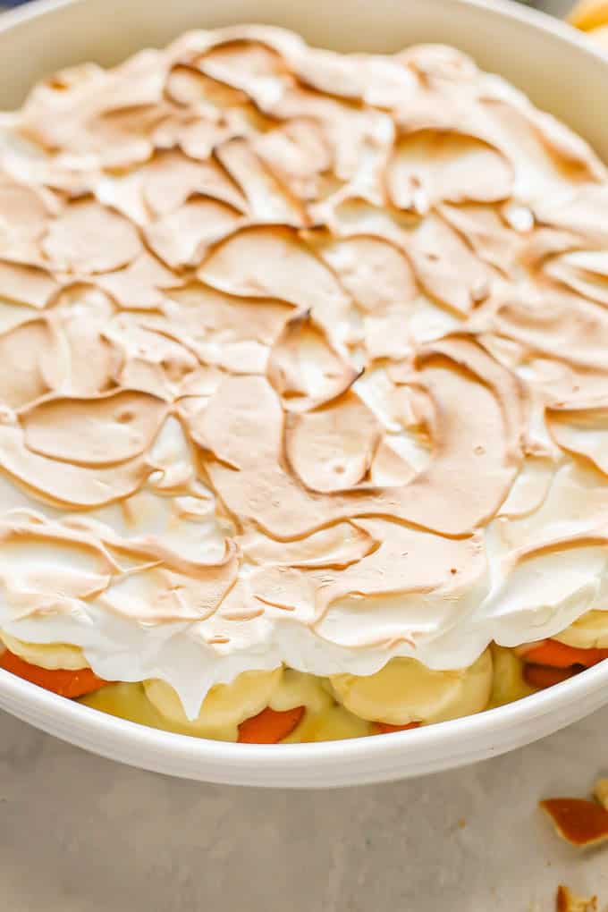 Close up of a large white round casserole dish with homemade banana pudding and meringue on top