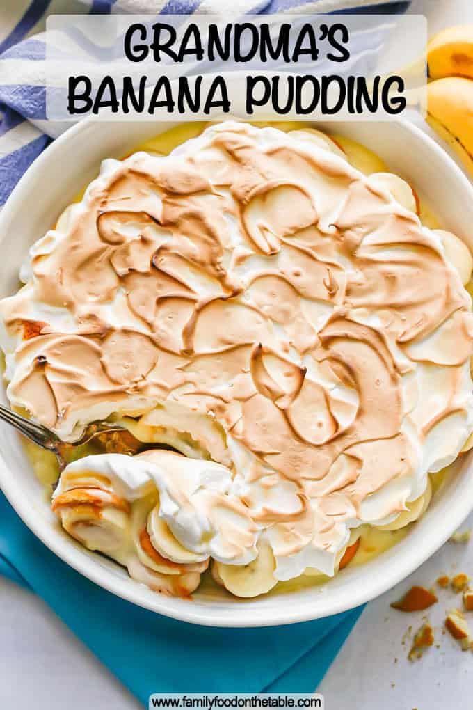 A large white round casserole dish with homemade banana pudding and meringue on top with a text overlay on the photo