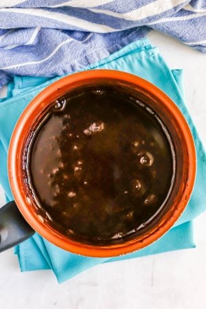 Homemade chocolate sauce being cooked in a small copper sauce pan