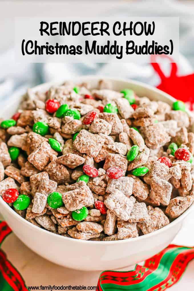 Reindeer chow mix in a large white bowl with Christmas ribbon laying nearby and a text overlay on the photo