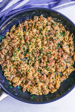 A large skillet with a turkey sausage, breadcrumb and Parmesan mixture