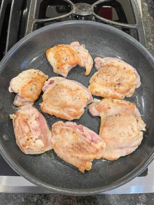 Browned boneless, skinless chicken thighs in a skillet
