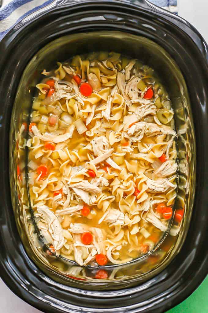 A crock pot full of chicken noodle soup