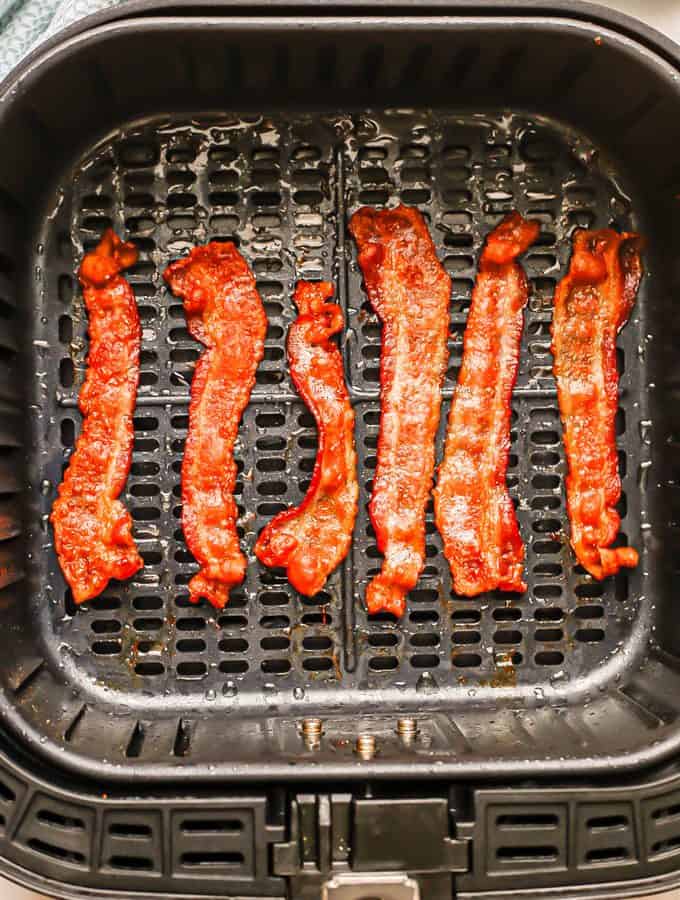 Strips of cooked, crispy bacon in an Air Fryer tray