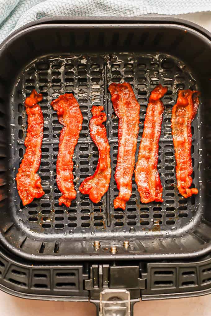 Strips of cooked, crispy bacon in an Air Fryer tray