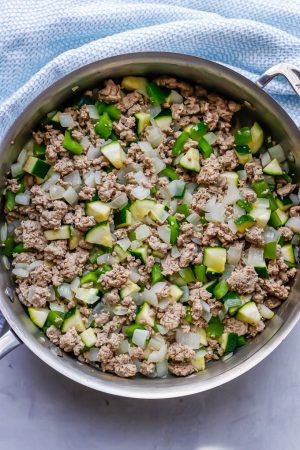 Cooked ground turkey and veggies in a large deep all clad pan