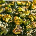 Close up of browned and roasted broccoli on a sheet pan with Parmesan on top and a text overlay on the photo