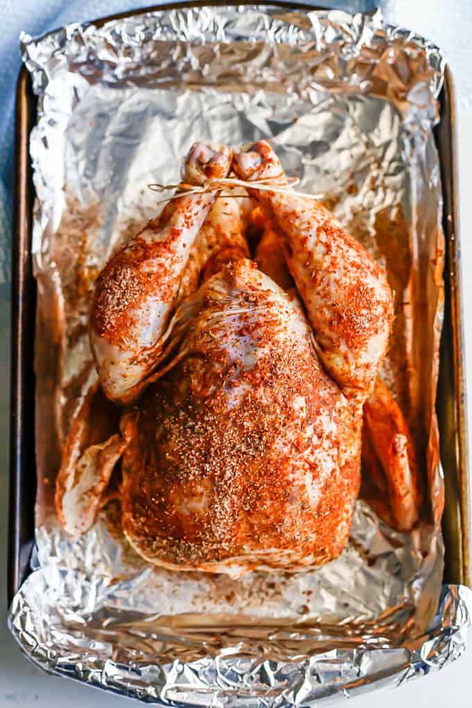 A whole chicken seasoned and tied before being cooked in the oven