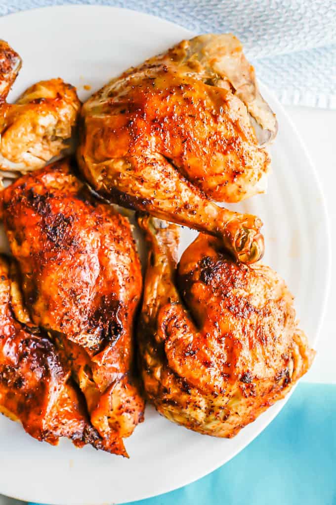 Cut pieces of a whole rotisserie style roast chicken served on a white platter