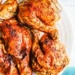 Cut pieces of a whole rotisserie style roast chicken served on a white platter with a text overlay on the photo