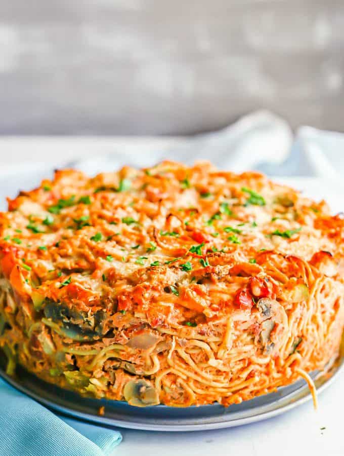 Side view of a thick baked chicken and veggie spaghetti pie