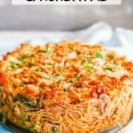 Side view of a thick baked chicken and veggie spaghetti pie with a text overlay on the photo