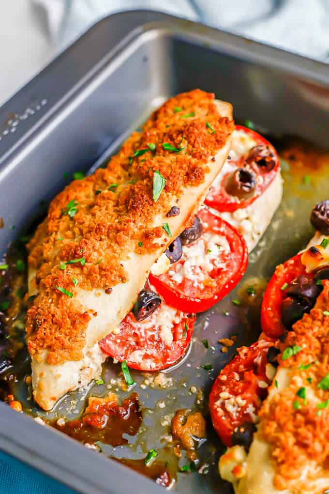 Close up of a Greek stuffed chicken breast in a baking pan after being roasted