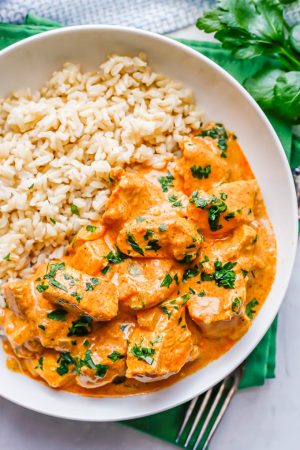 Instant Pot butter chicken served with rice in a low white bowl