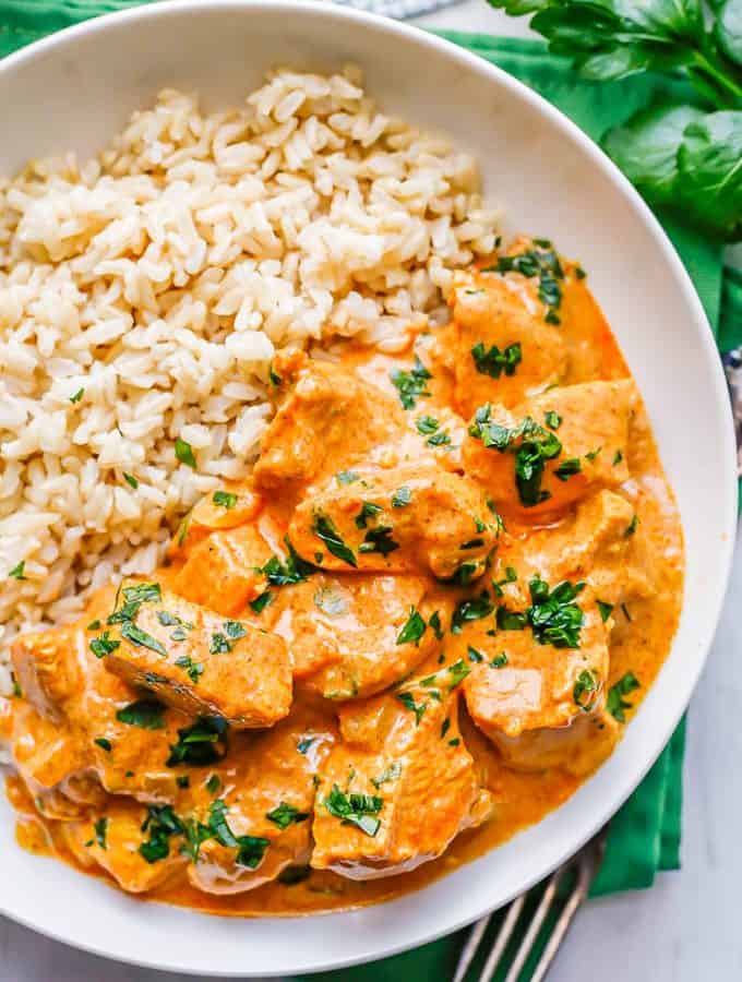 Instant Pot butter chicken served with rice in a low white bowl