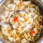 A ladle full of chicken noodle soup being lifted from an Instant Pot insert with a text overlay on the photo