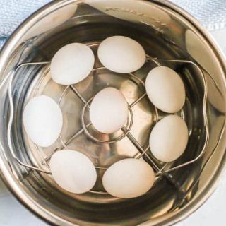 Hard boiled eggs set on a rack in an Instant Pot insert before being cooked