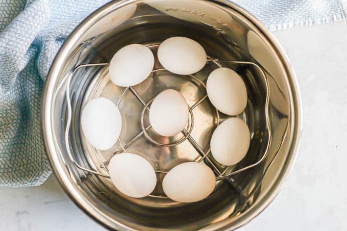 Hard boiled eggs set on a rack in an Instant Pot insert before being cooked