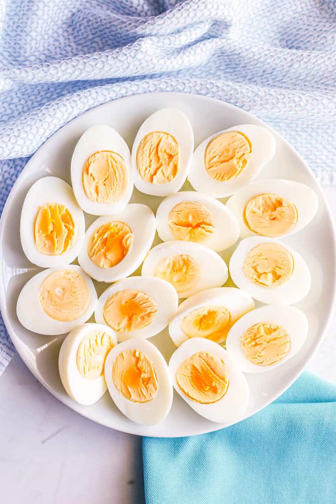 A white platter full of halved hard boiled eggs