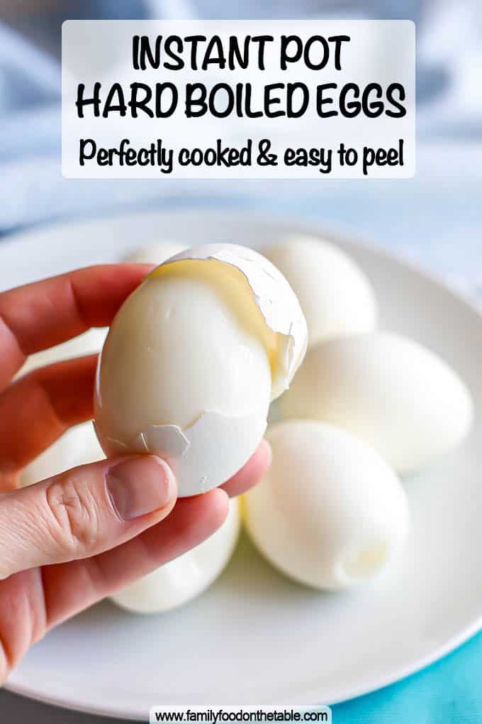 A hand holding a hard boiled egg with the shell being removed and a text overlay on the photo