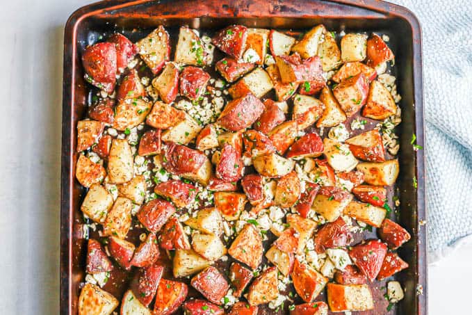 A sheet pan of roasted red potatoes with herbs and feta cheese