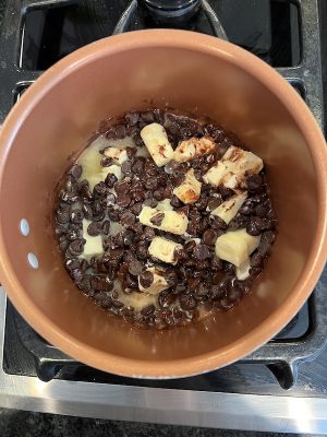 Butter and chocolate chips being melted together in a copper pot
